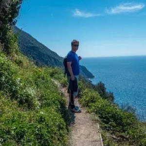 mann ved sti og utsikt mot hav