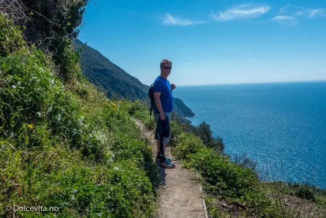 mann ved sti og utsikt mot hav